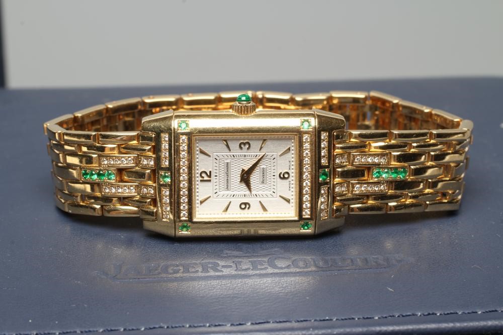 A LADY'S JAEGER-LECOULTRE EMERALD AND DIAMOND REVERSO WRISTWATCH/BRACELET Image