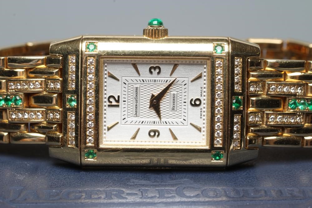 A LADY'S JAEGER-LECOULTRE EMERALD AND DIAMOND REVERSO WRISTWATCH/BRACELET Image