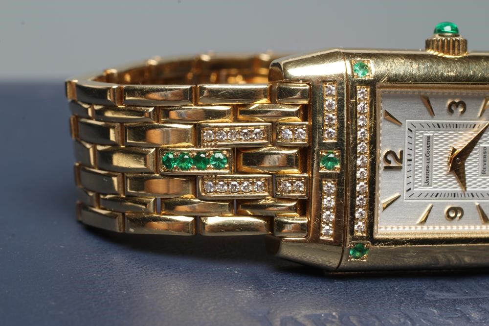 A LADY'S JAEGER-LECOULTRE EMERALD AND DIAMOND REVERSO WRISTWATCH/BRACELET Image