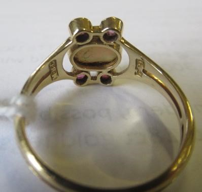 A MURRLE BENNETT DRESS RING, the oval cabochon polished opal collet set with two pairs of small Image