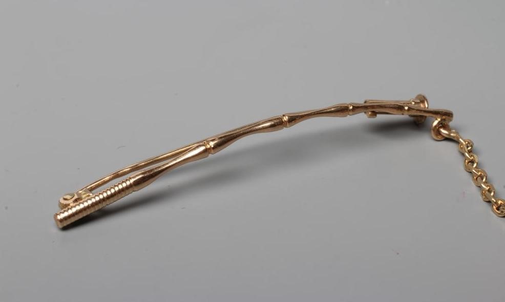 A NOVELTY FISHING BROOCH, the scaley articulated fish with ruby eyes, on a chain "line" and faux Image