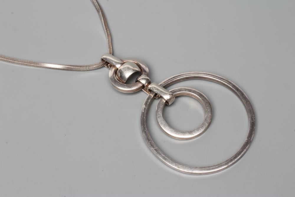 A GROSSE OF GERMANY SILVER PENDANT comprising two concentric circlets loose in mount on a fixed Image