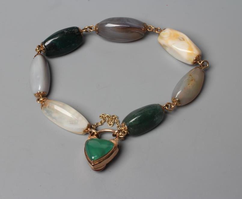 A VICTORIAN SCOTTISH PEBBLE BRACELET, the seven polished stones with unmarked metal links between Image