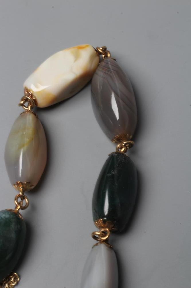 A VICTORIAN SCOTTISH PEBBLE BRACELET, the seven polished stones with unmarked metal links between Image