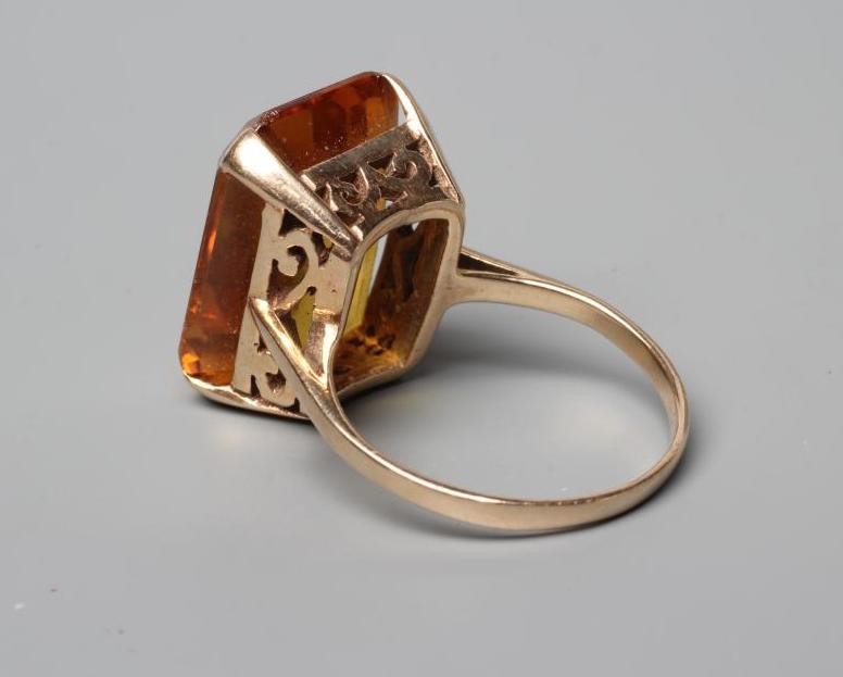 A COCKTAIL RING claw set with an oblong facet cut citrine to a plain, unmarked shank, size N (Est. Image