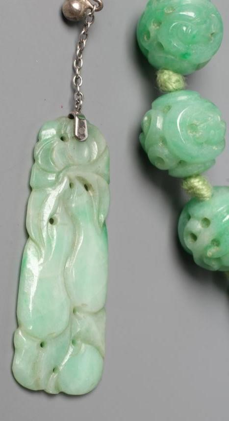 A CHINESE JADE NECKLACE, the twenty nine spherical beads carved and pierced with scrolling foliage, Image