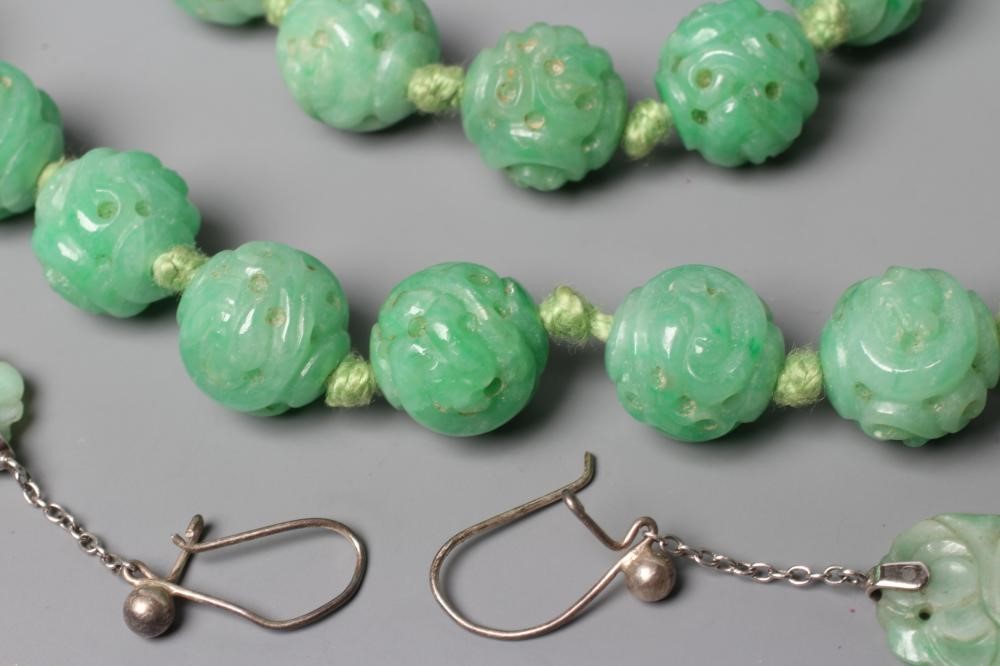 A CHINESE JADE NECKLACE, the twenty nine spherical beads carved and pierced with scrolling foliage, Image