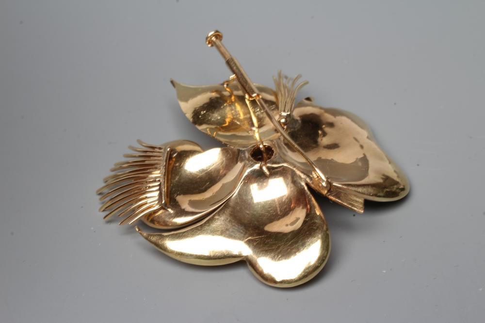 A COCKTAIL BROOCH, the large four petalled flowerhead with numerous small rubies claw set to the Image