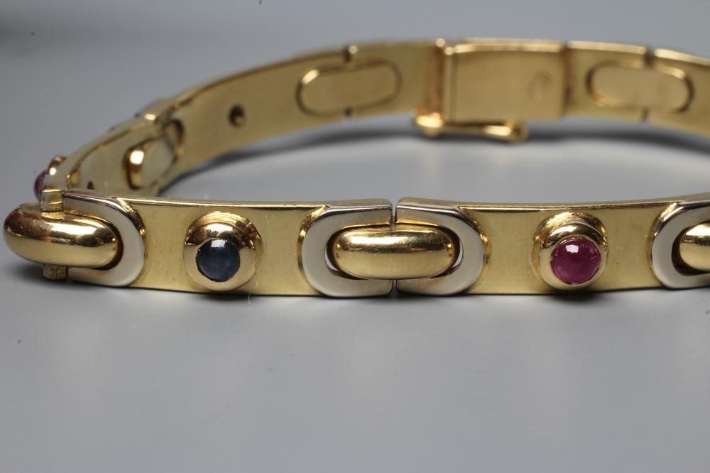 A BRACELET stamped 750, the seven slightly convex oblong panels alternately set with a cabochon Image