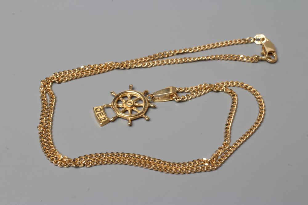 A SOUVENIR PENDANT cast as a ship's wheel and titled "QE2", stamped 18k, on an 18ct gold flat link Image