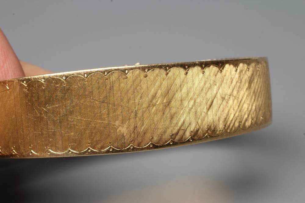 AN ARTICULATED BRACELET, the finely engine turned oblong links with a swag engraved border and slide Image