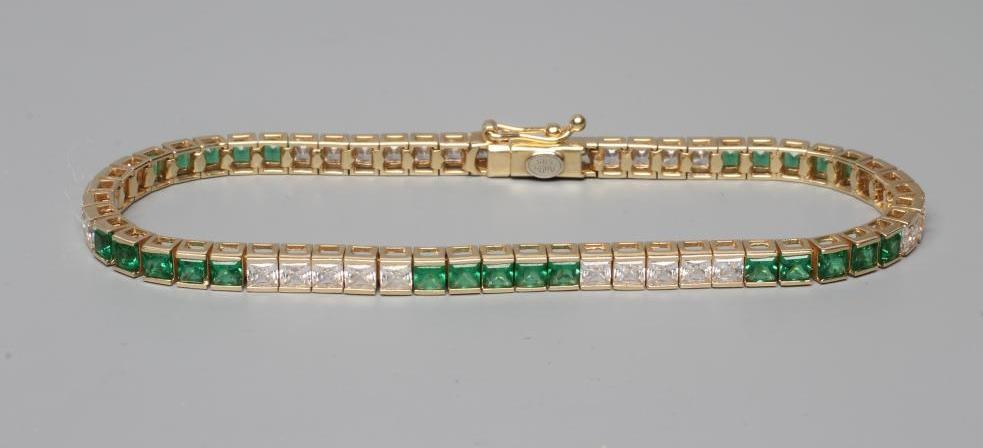 A TENNIS BRACELET bar set with five sets of five square cut green and white pastes Image