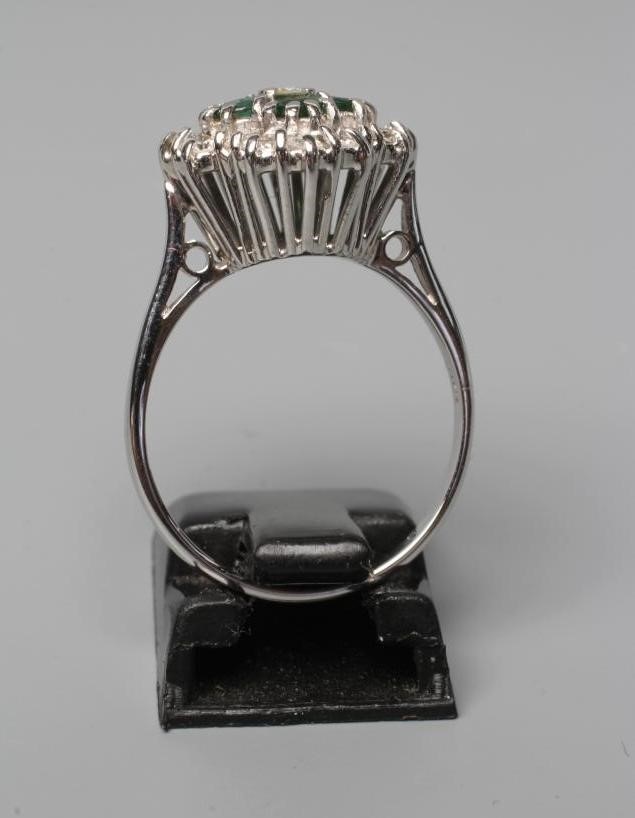 AN EMERALD AND DIAMOND CLUSTER RING Image
