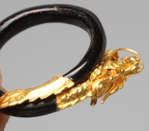 A BANGLE AND MATCHING RING, probably Chinese, possibly lacquered wood, each with a yellow metal Image