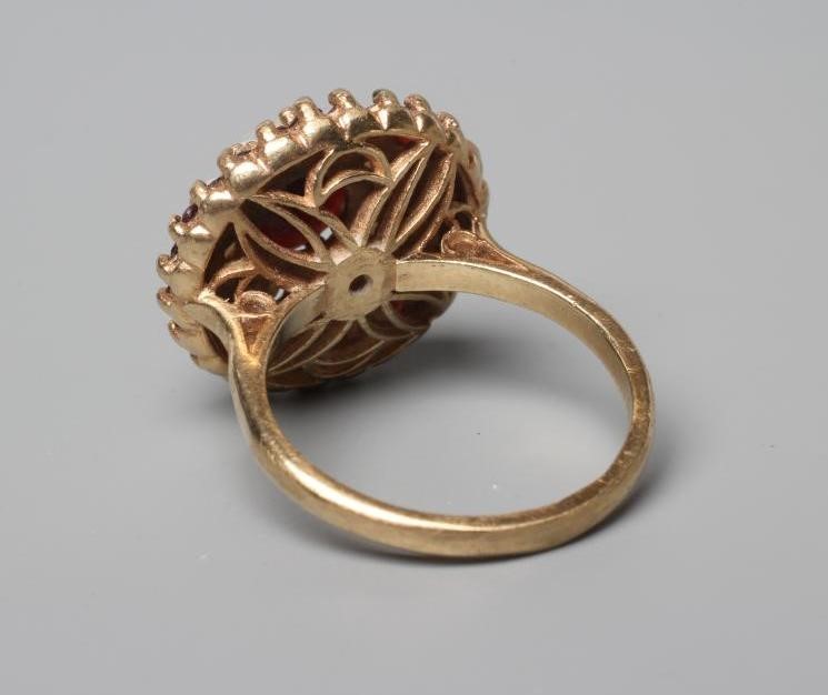 A GARNET AND SEED PEARL CLUSTER RING, point and claw set to a plain shank stamped 9ct, size R (Est. Image