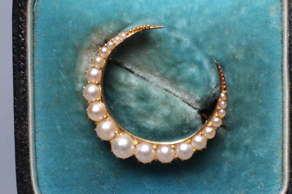 AN EDWARDIAN CRESCENT BROOCH set with nineteen blister pearls to a plain frame stamped 15, cased, Image