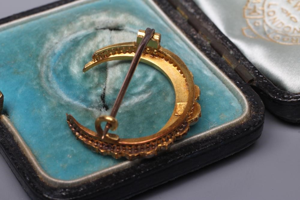AN EDWARDIAN CRESCENT BROOCH set with nineteen blister pearls to a plain frame stamped 15, cased, Image