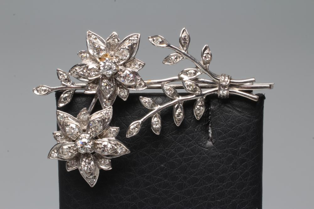 A DIAMOND FLOWER SPRAY BROOCH, the two flowerhead clusters with three leafy branches to an unmarked Image