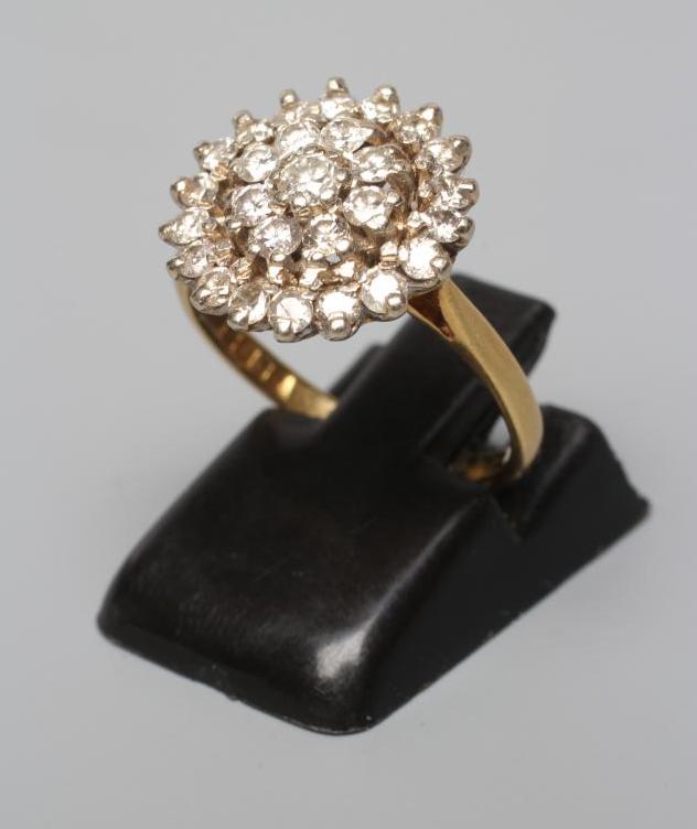 A DIAMOND CLUSTER RING, the central stone within a double border of point set stones to a plain 18ct Image