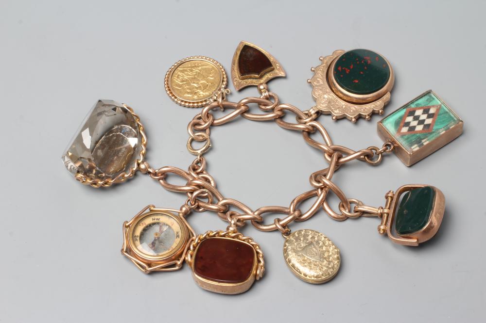 A 9CT GOLD CHARM BRACELET hung with a loose mounted 1912 sovereign Image