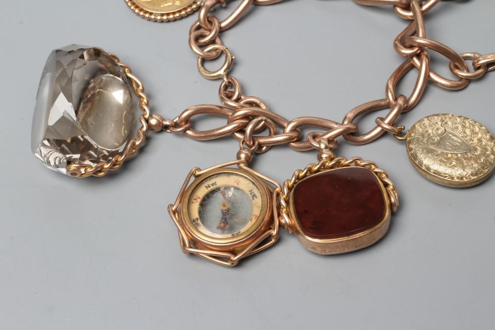A 9CT GOLD CHARM BRACELET hung with a loose mounted 1912 sovereign Image