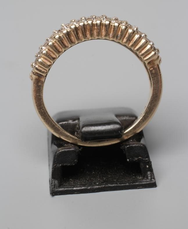 A THREE ROW DIAMOND HALF HOOP RING, the small round brilliants point set between bead borders to a Image