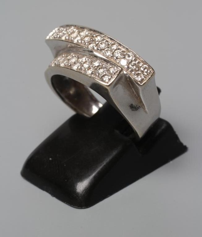 A DIAMOND CROSSOVER STYLE RING, the two panels point set with numerous small stones to a wide white Image