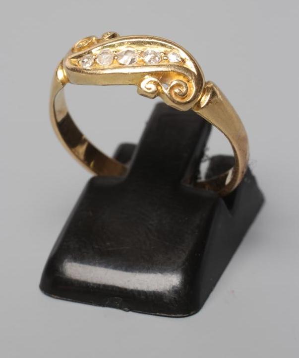A VICTORIAN FIVE STONE DIAMOND CROSSOVER RING, the small stones point set to scroll carved shoulders Image