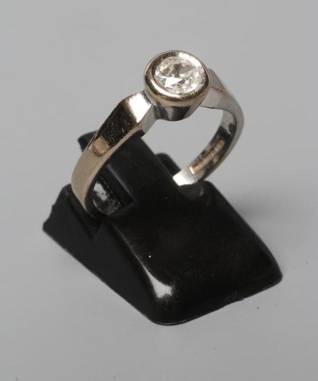 A SOLITAIRE DIAMOND RING, the brilliant cut stone of approximately 0.30cts in rub-over setting to a Image