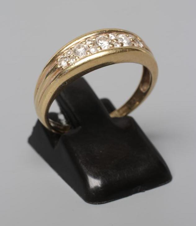 A DIAMOND HALF HOOP RING, the five graduated stones with pairs of diamond point spacers to reeded Image