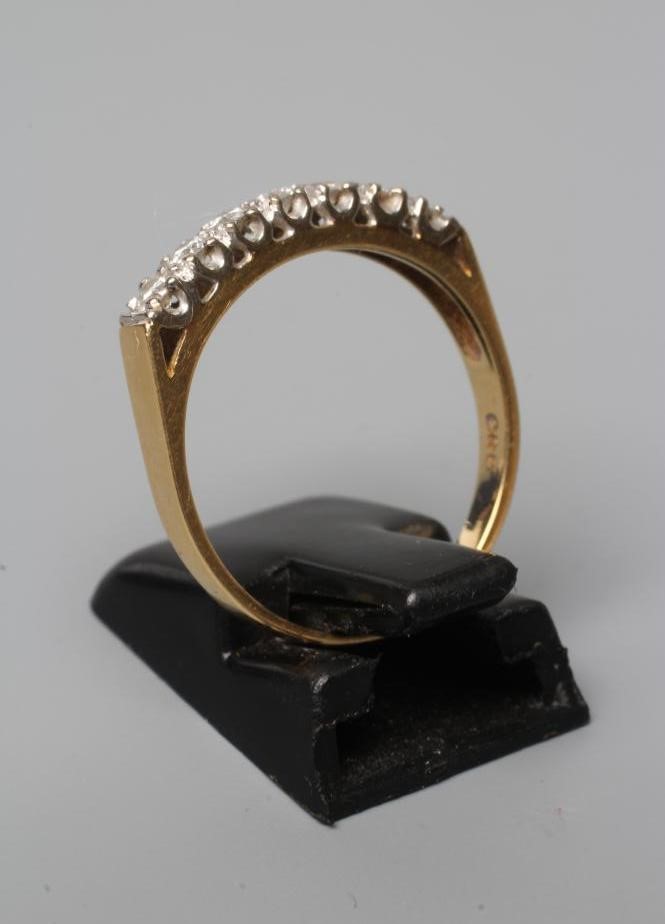 A SEVEN STONE DIAMOND HALF HOOP ETERNITY RING, the brilliant cut stones point set to a plain 18ct Image