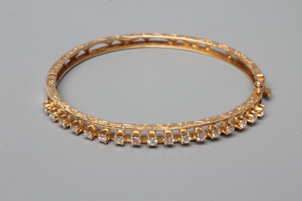 A DIAMOND SET STIFF HINGED BANGLE, the upper section claw set with seventeen small round brilliant Image