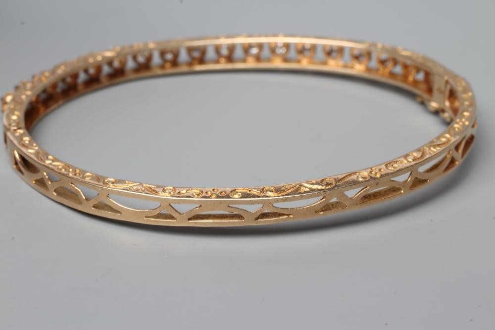 A DIAMOND SET STIFF HINGED BANGLE, the upper section claw set with seventeen small round brilliant Image