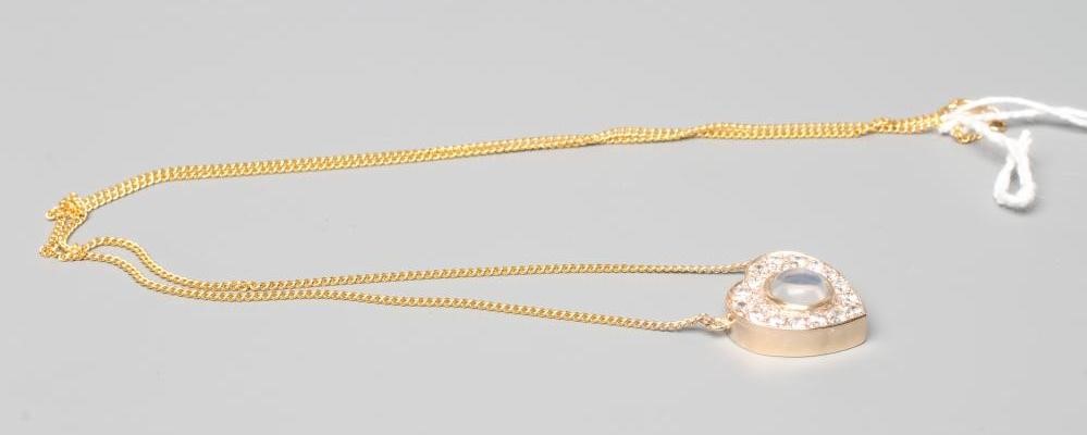 A MOONSTONE AND DIAMOND CLUSTER HEART PENDANT Image