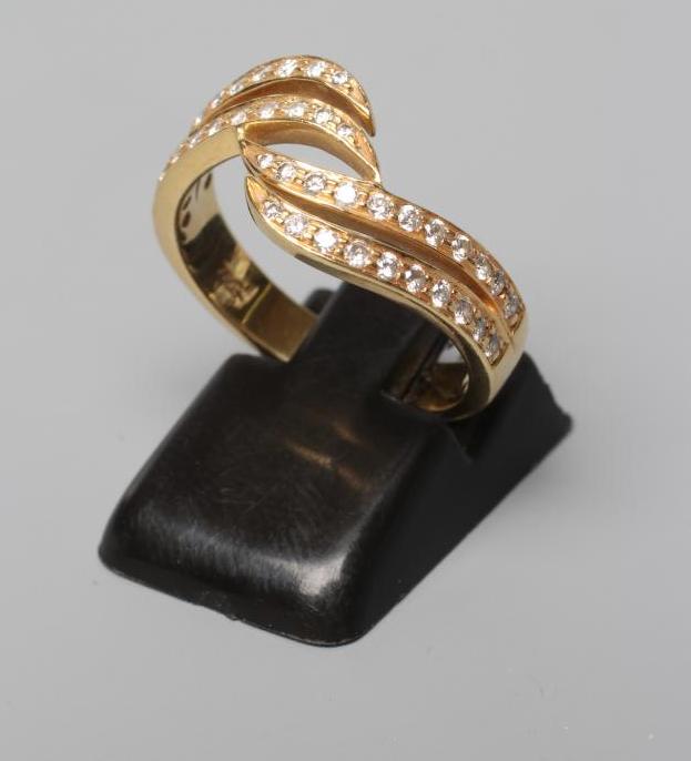 A DIAMOND HALF HOOP DRESS RING, the four scroll panels all point set with small stones to a plain Image