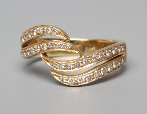 A DIAMOND HALF HOOP DRESS RING, the four scroll panels all point set with small stones to a plain Image