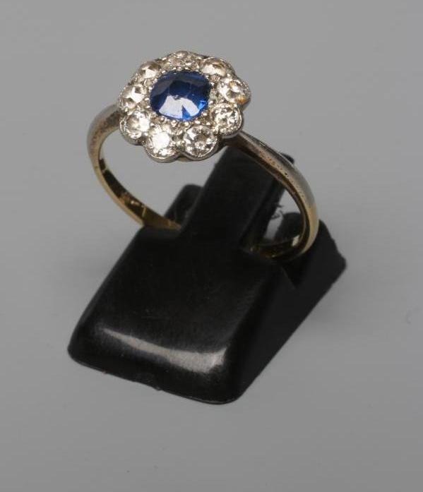 A SAPPHIRE AND DIAMOND CLUSTER RING, the central cushion cut sapphire set to a border of nine old Image