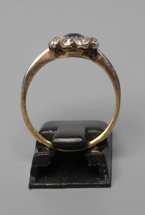A SAPPHIRE AND DIAMOND CLUSTER RING, the central cushion cut sapphire set to a border of nine old Image
