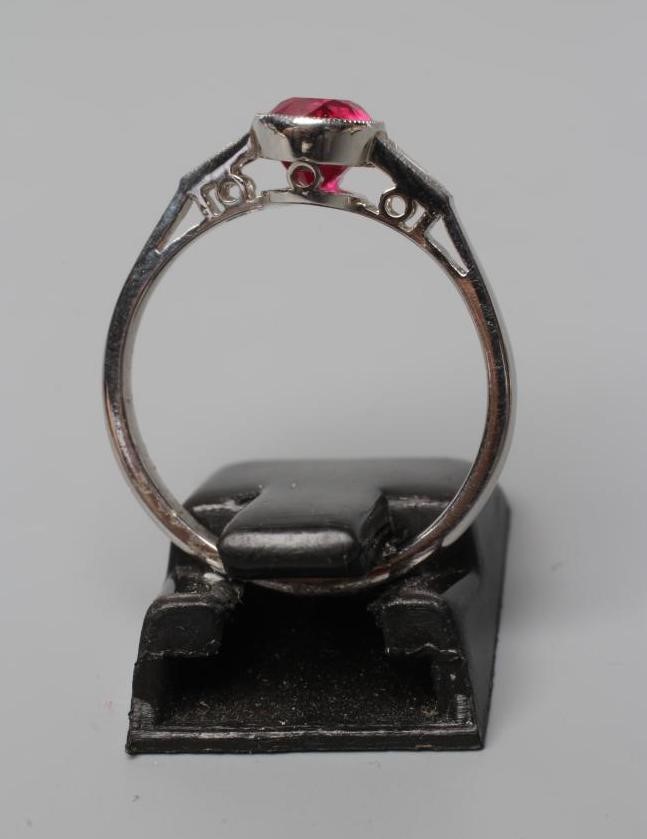 A RUBY RING, the oval facet cut stone of 1.27cts, collet set to shaped shoulders each set with a Image