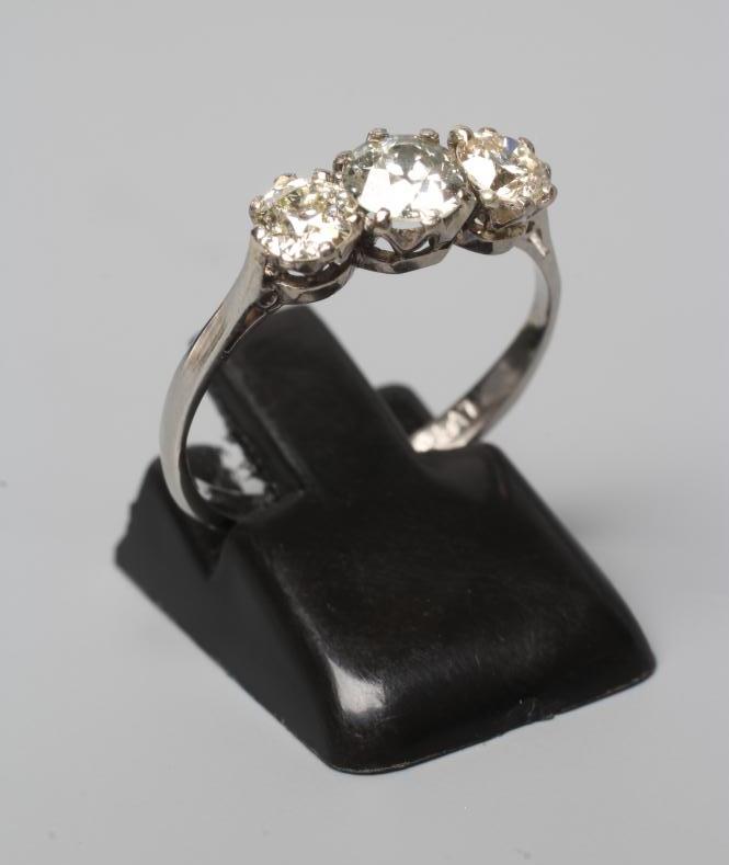A THREE STONE DIAMOND RING, the old cut stones claw set and totalling approximately 0.8cts, to a Image