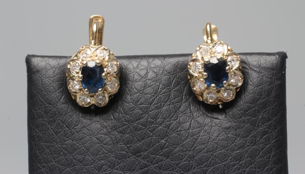 A PAIR OF SAPPHIRE AND DIAMOND CLUSTER EARRINGS, the oval facet cut sapphire claw set to a border of Image