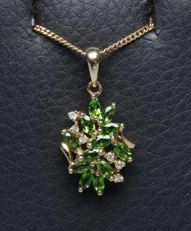 A TSAVORITE GARNET AND DIAMOND ABSTRACT CLUSTER PENDANT, stamped 14k, on a 9ct gold fine chain Image