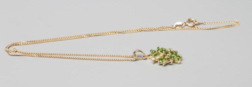A TSAVORITE GARNET AND DIAMOND ABSTRACT CLUSTER PENDANT, stamped 14k, on a 9ct gold fine chain Image