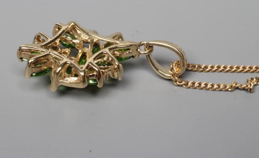 A TSAVORITE GARNET AND DIAMOND ABSTRACT CLUSTER PENDANT, stamped 14k, on a 9ct gold fine chain Image
