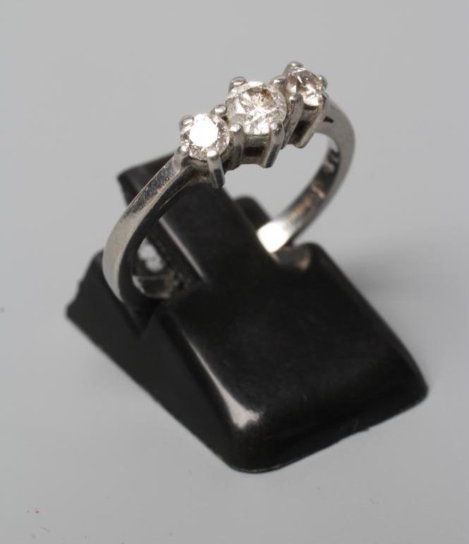 A THREE STONE DIAMOND RING, the three round brilliant cut stones totalling 0.50cts, claw set to a Image