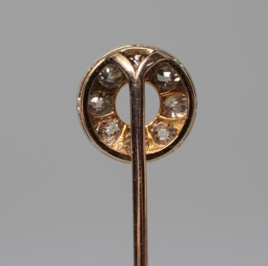 A DIAMOND STICK PIN, the "doughnut" finial pave set with eight old cut stones to a plain unmarked Image