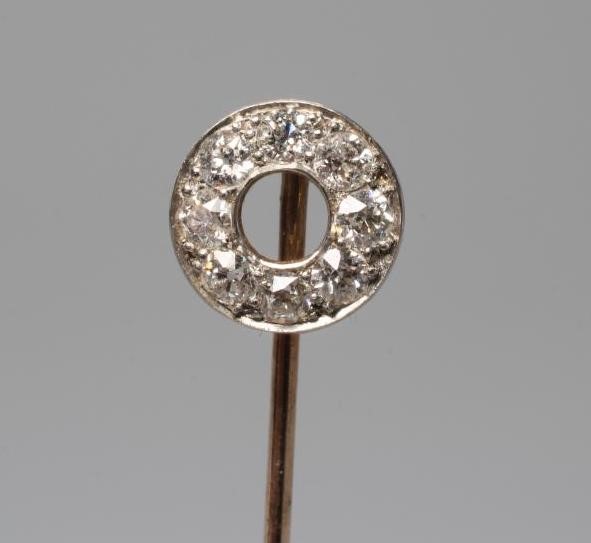 A DIAMOND STICK PIN, the "doughnut" finial pave set with eight old cut stones to a plain unmarked Image