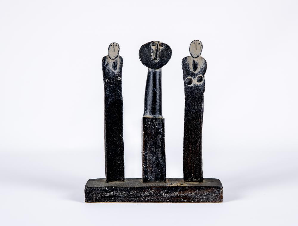 JOHN MALTBY (1936-2000) - a matt black stoneware sculpture of three standing figures on a plain Image