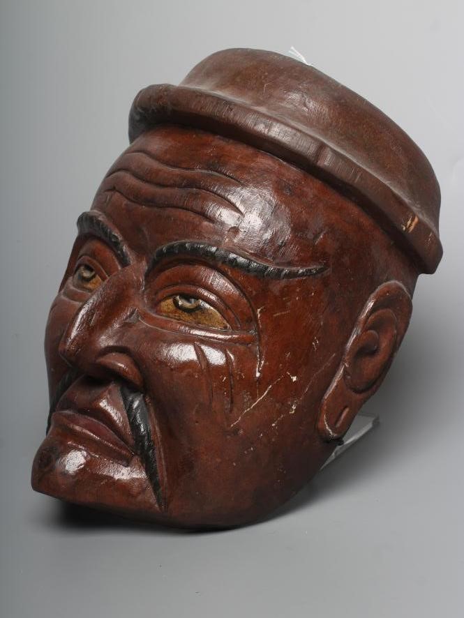 A JAPANESE CARVED WOOD NOH MASK painted in red, black and white, with holes for the eyes and Image