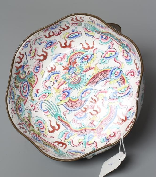 A CANTON ENAMEL BOWL of lobed circular form, painted in bright colours with dragons on a white Image